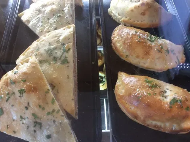 A variety of pastries are displayed in a glass case.