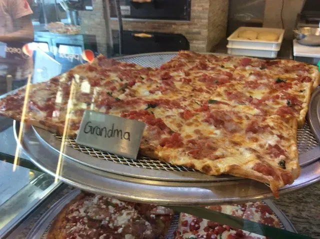 A slice of pizza with a sign that says grandma on it