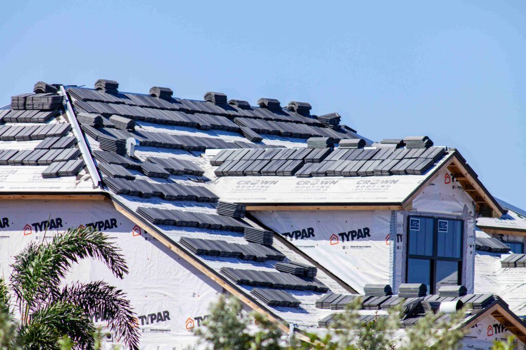 A house is being built with a roof that is being installed.