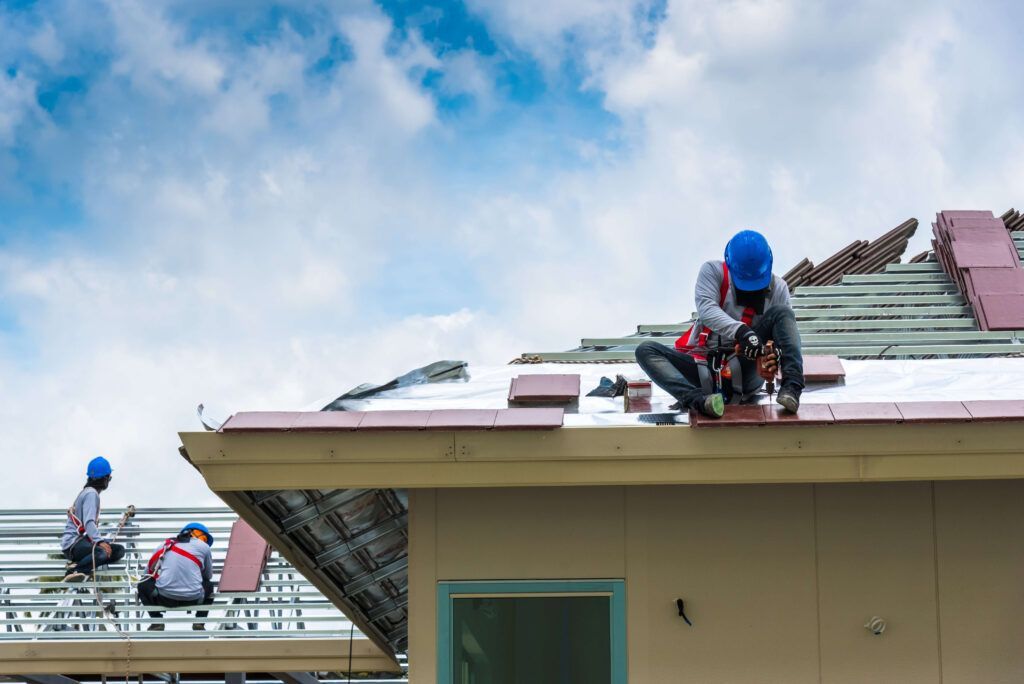 A group of construction workers are working on the roof of a building.