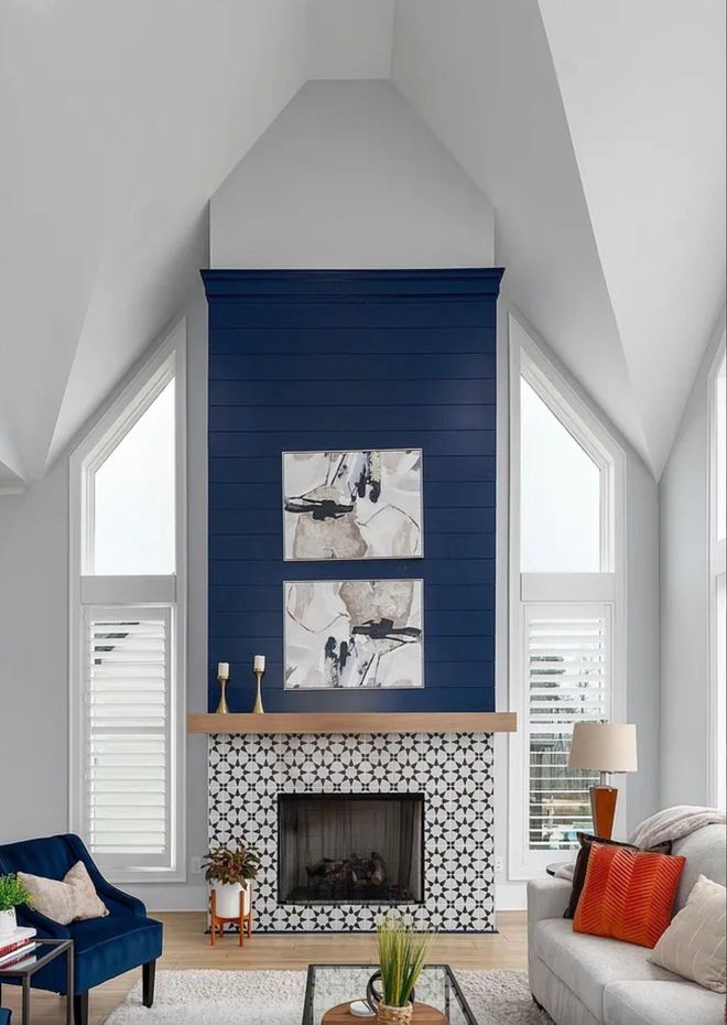 Living room with navy blue fireplace, white walls, and geometric tile.