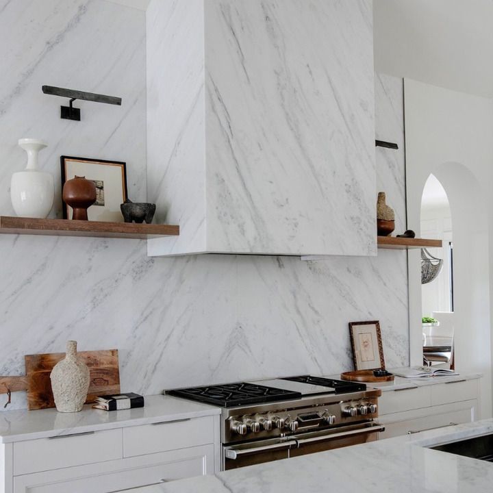 A kitchen with white cabinets and a stove top oven