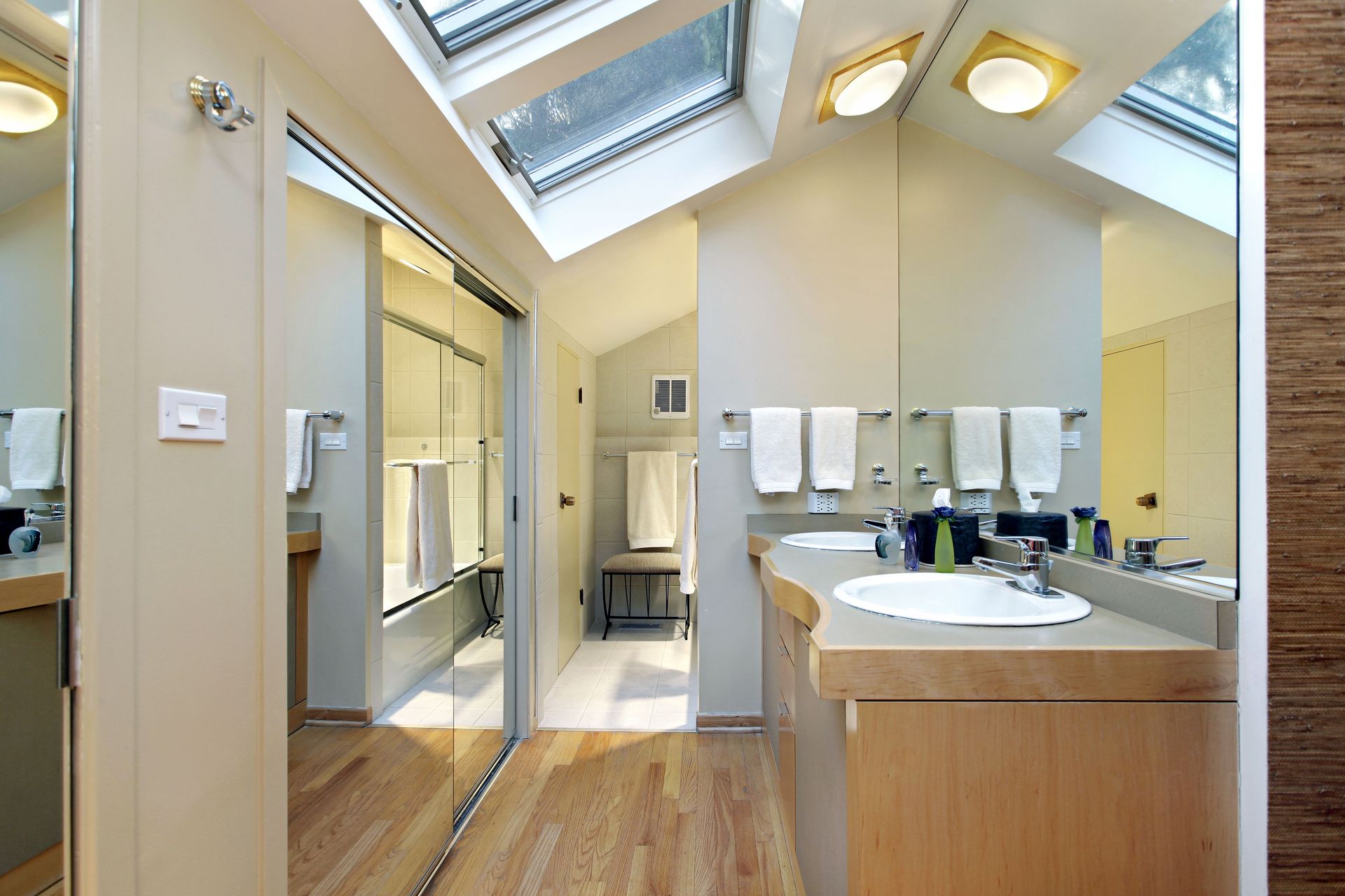 A bathroom with a skylight and two sinks