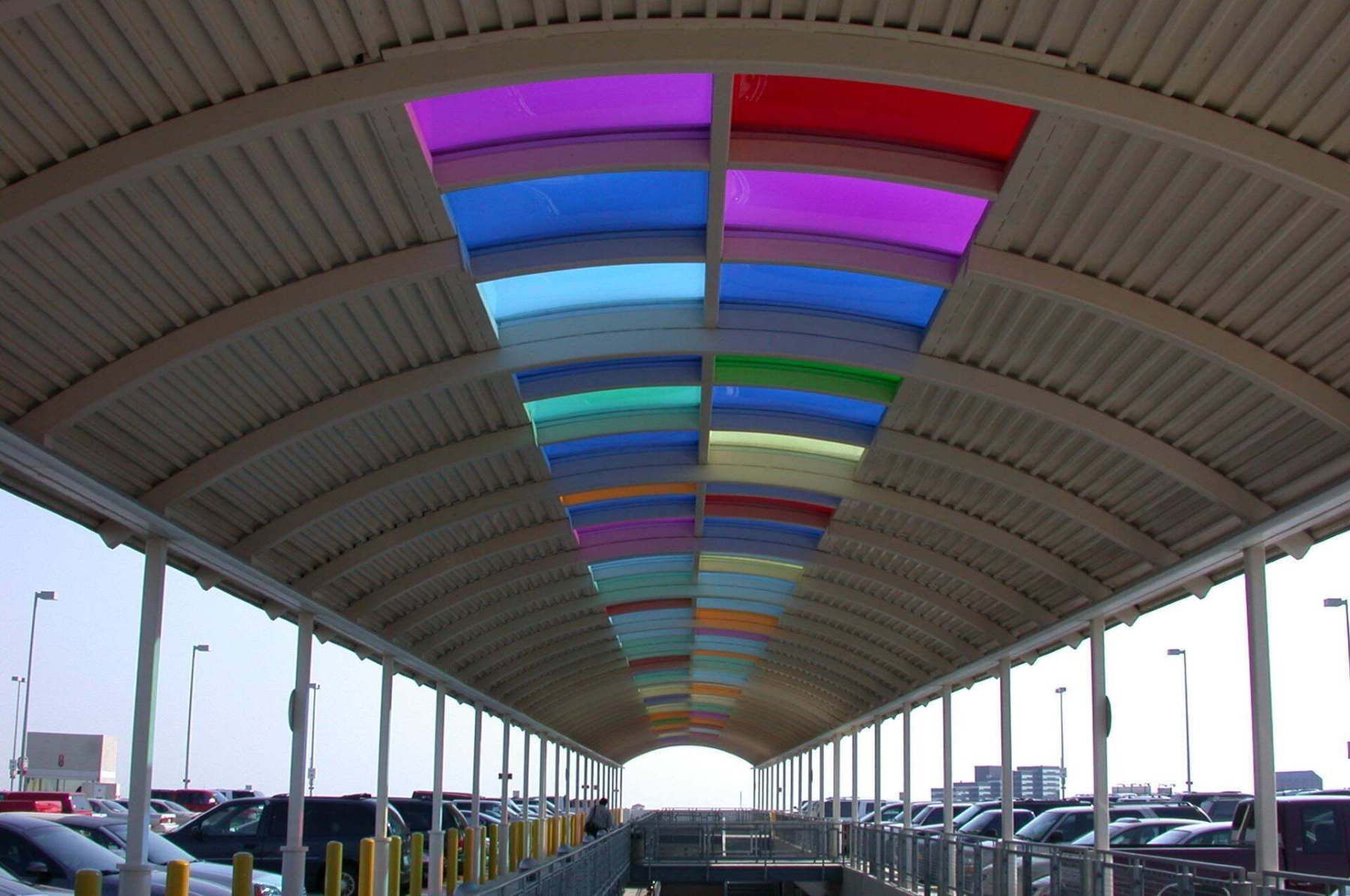 A covered walkway with a rainbow of colors on the ceiling