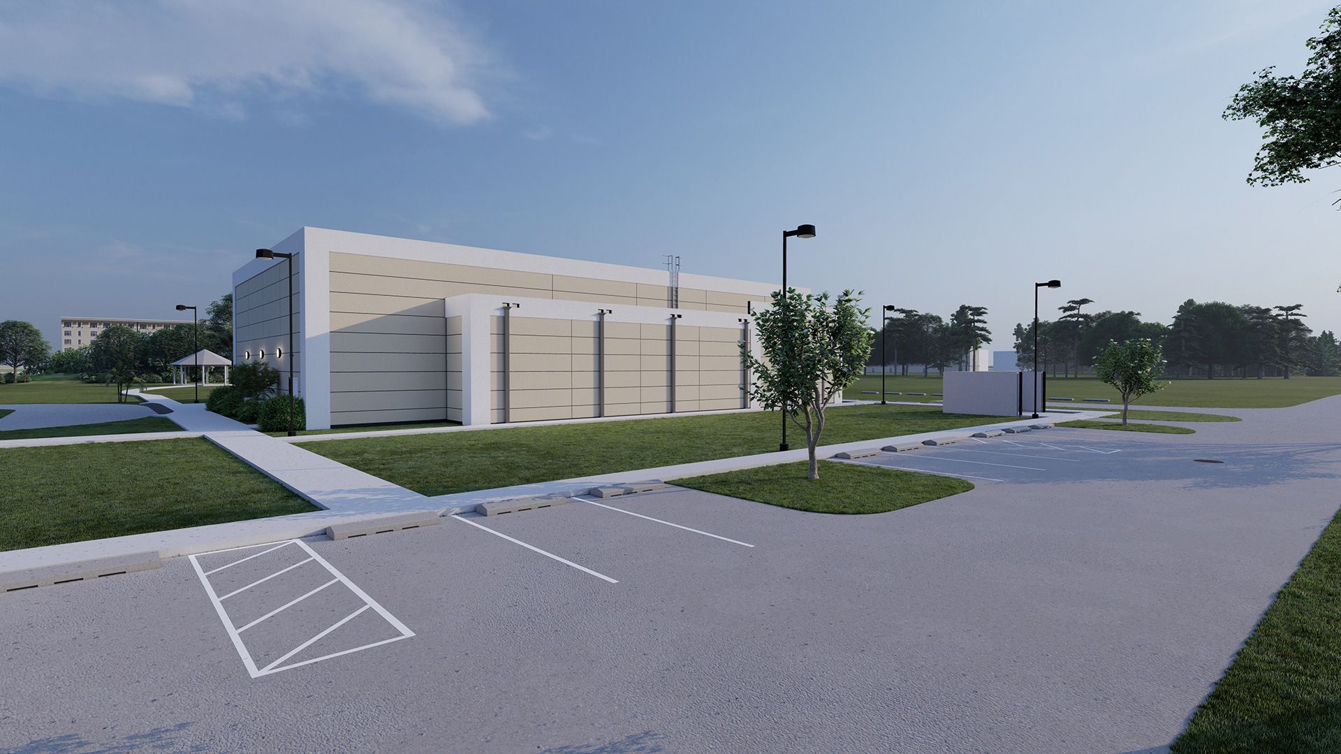 Exterior view of a modern building with parking, grass, trees, and streetlights under a blue sky.