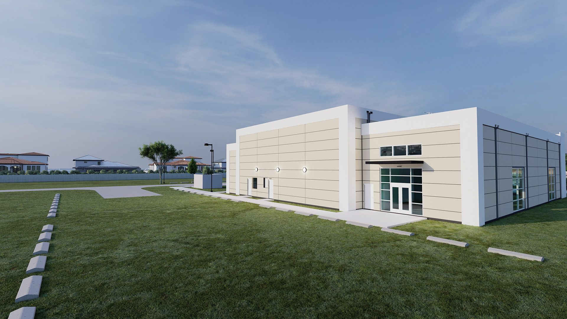 Modern, beige, and white building with a glass door, surrounded by green grass and blue sky.