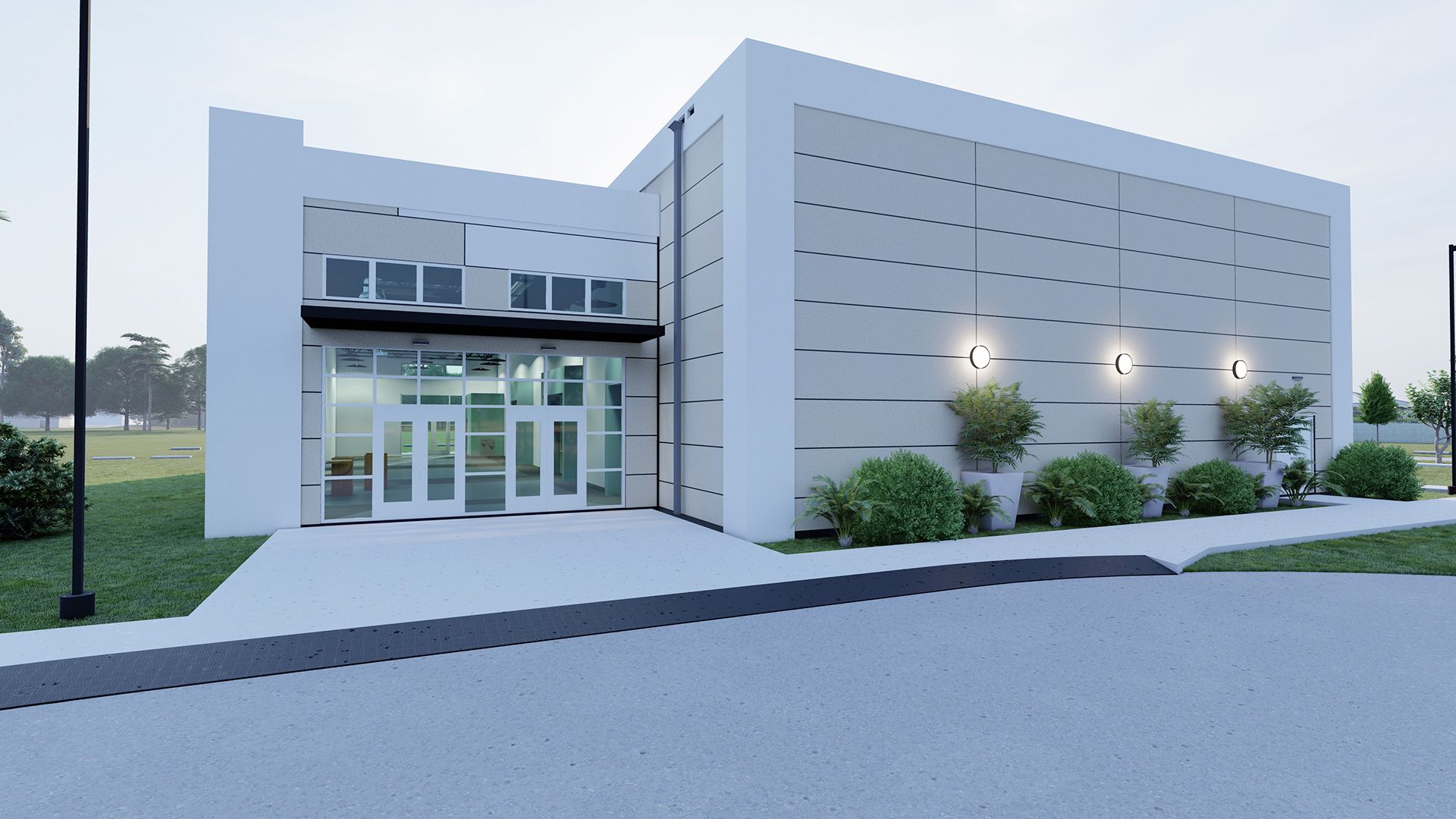 Modern building with a glass entrance, gray siding, and a walkway. Exterior, daytime.