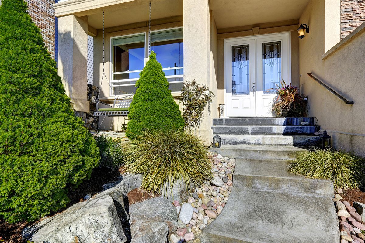 The front of a house with stairs leading up to the front door.