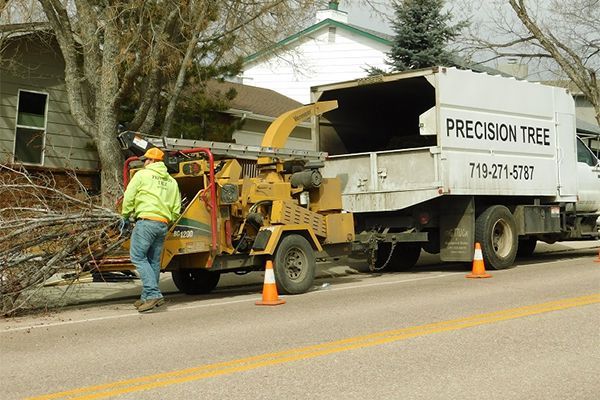 A precision tree truck is parked on the side of the road