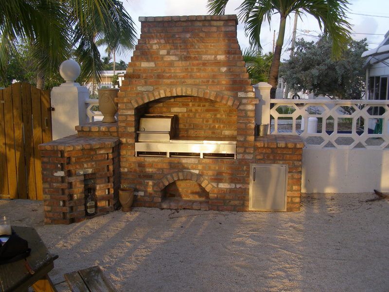 A brick fireplace with a grill inside of it