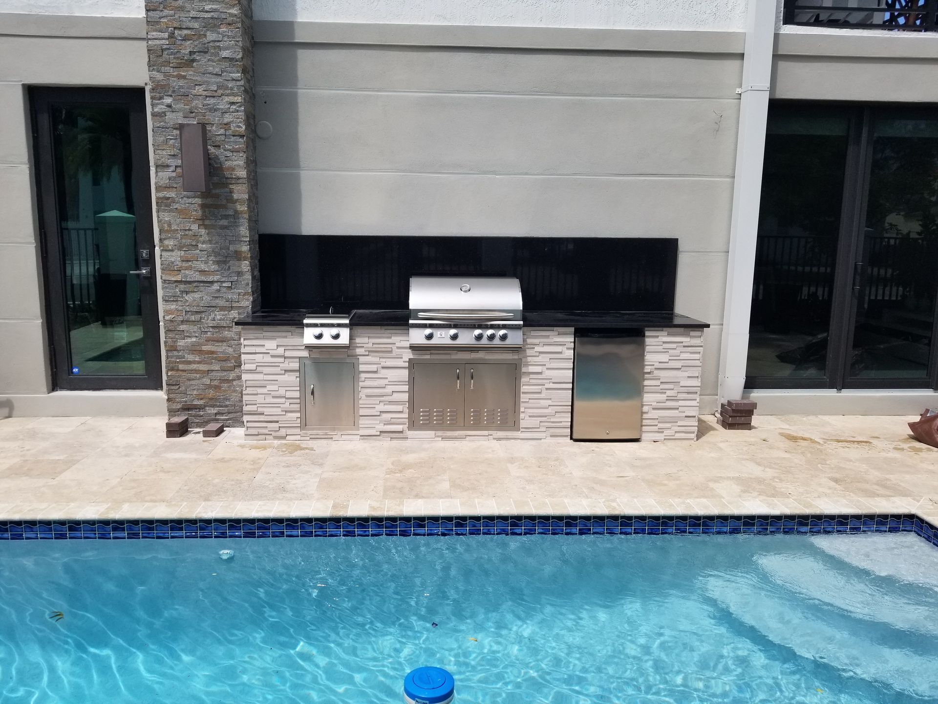 A swimming pool with a grill in the middle of it
