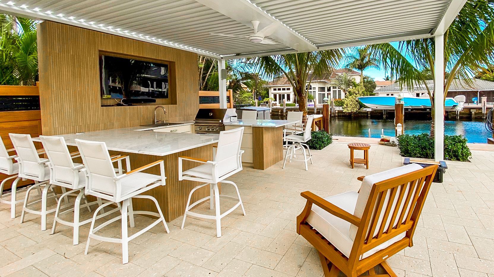 Outdoor kitchen with BBQ grill and stainless steel appliances in Lighthouse Point, FL.