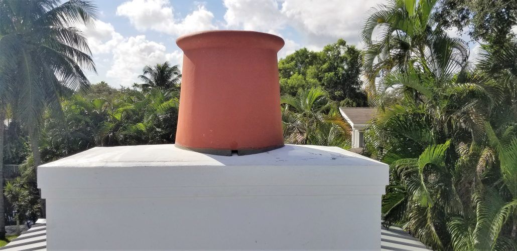 A white chimney with a red chimney on top of it.