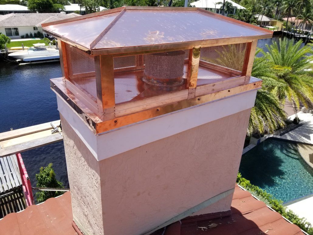 A chimney on top of a roof with a copper roof