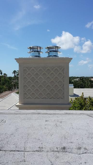 Two chimneys are sitting on top of a roof on a sunny day.