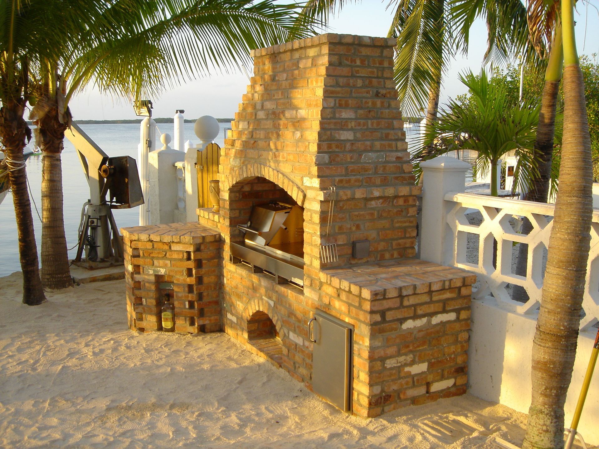 A large brick fireplace sits on a sandy beach