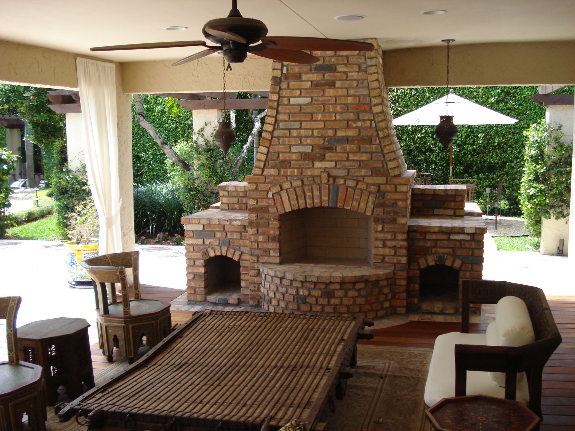 A living room with a brick fireplace and a pool table
