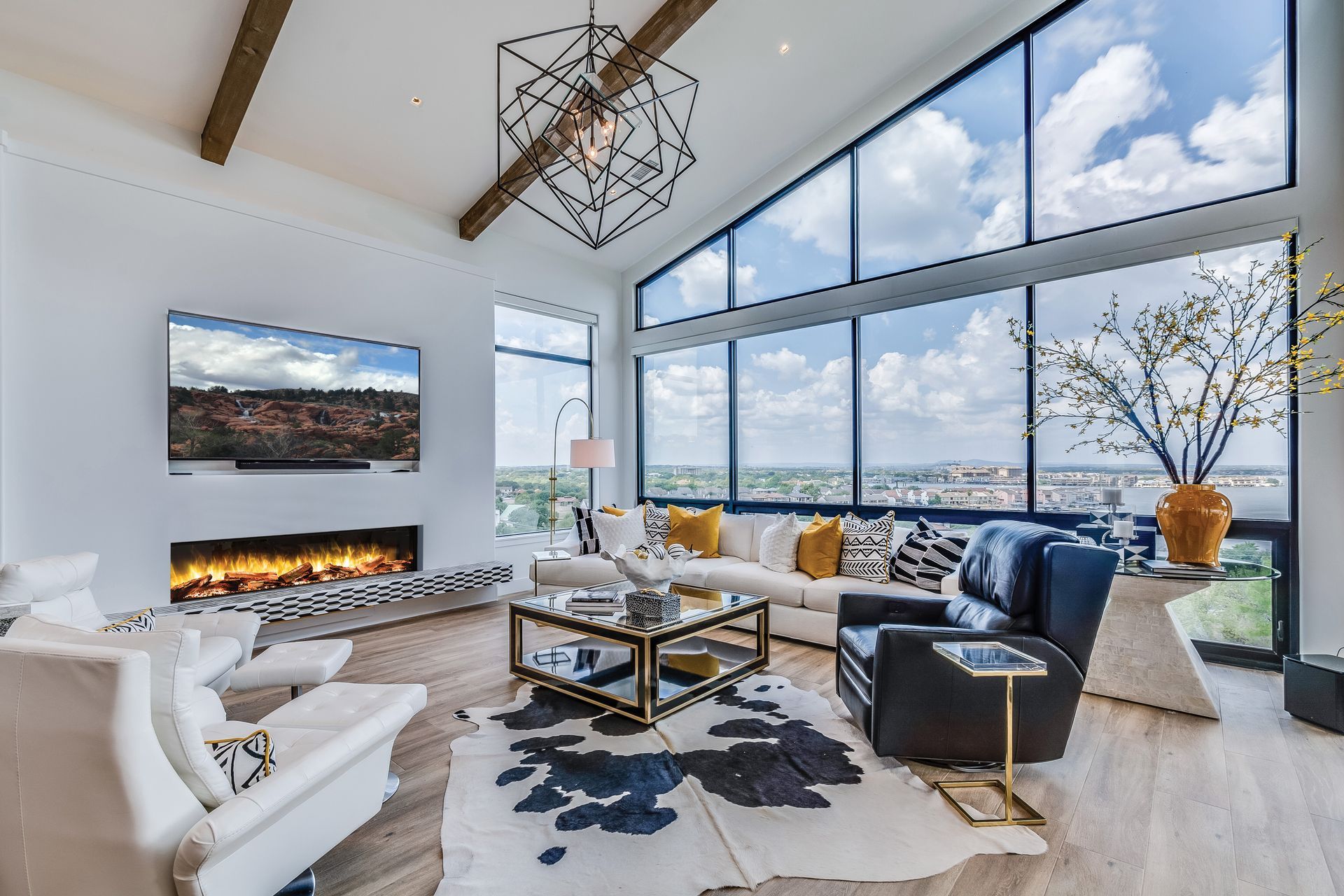 A living room with a couch , chairs , coffee table and television.