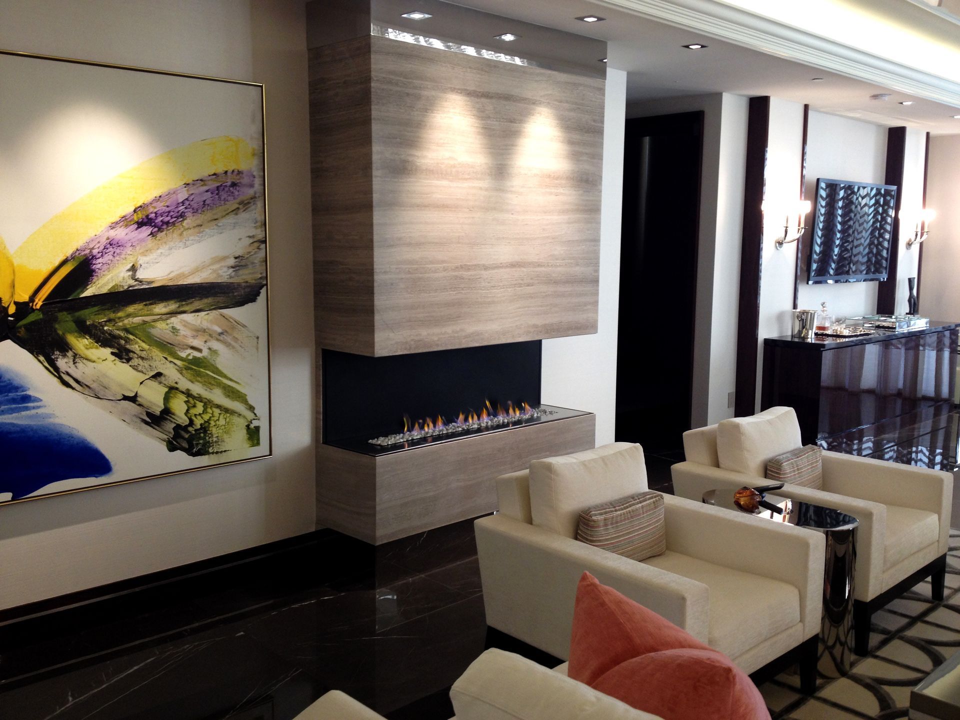 A living room with a fireplace and a painting on the wall