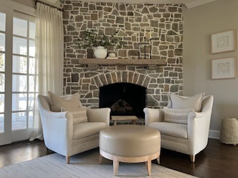 Cozy seating area with a stone fireplace and armchairs in Delray Beach, FL.