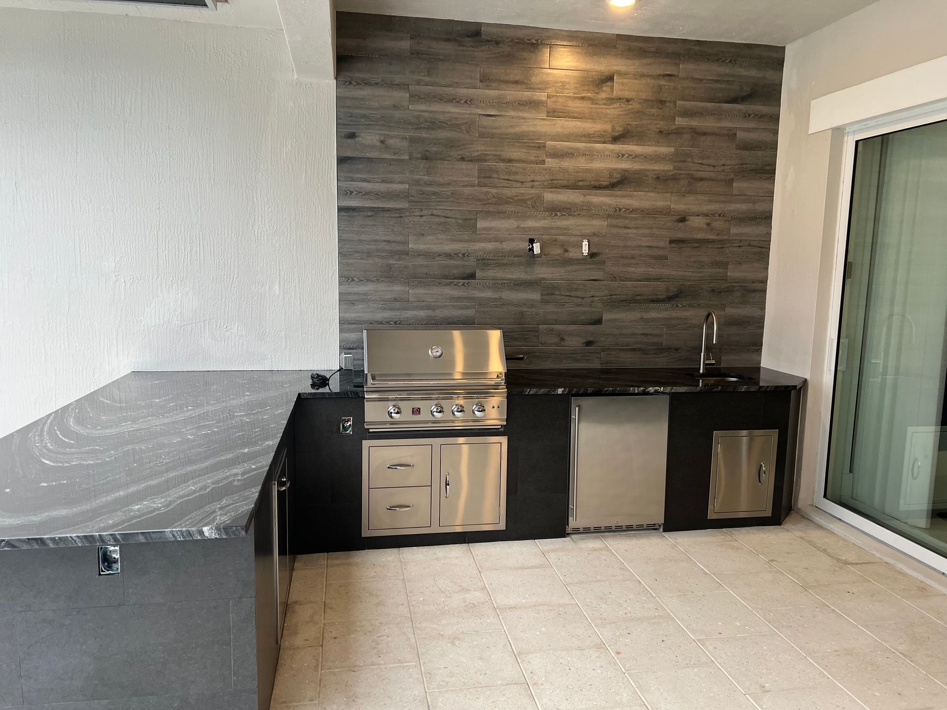 A kitchen with a stainless steel grill and a sink