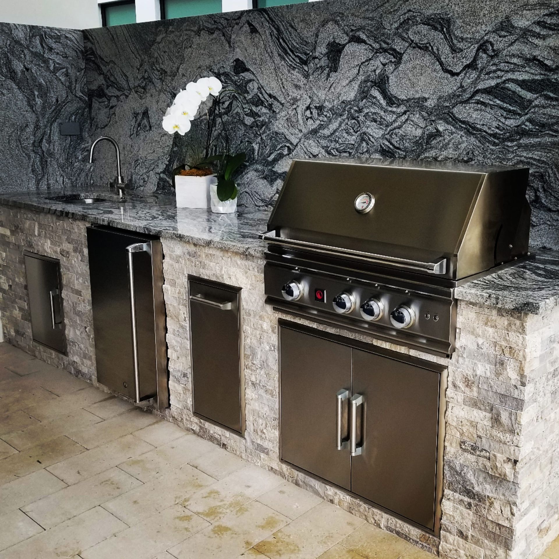 A kitchen with stainless steel cabinets and a grill