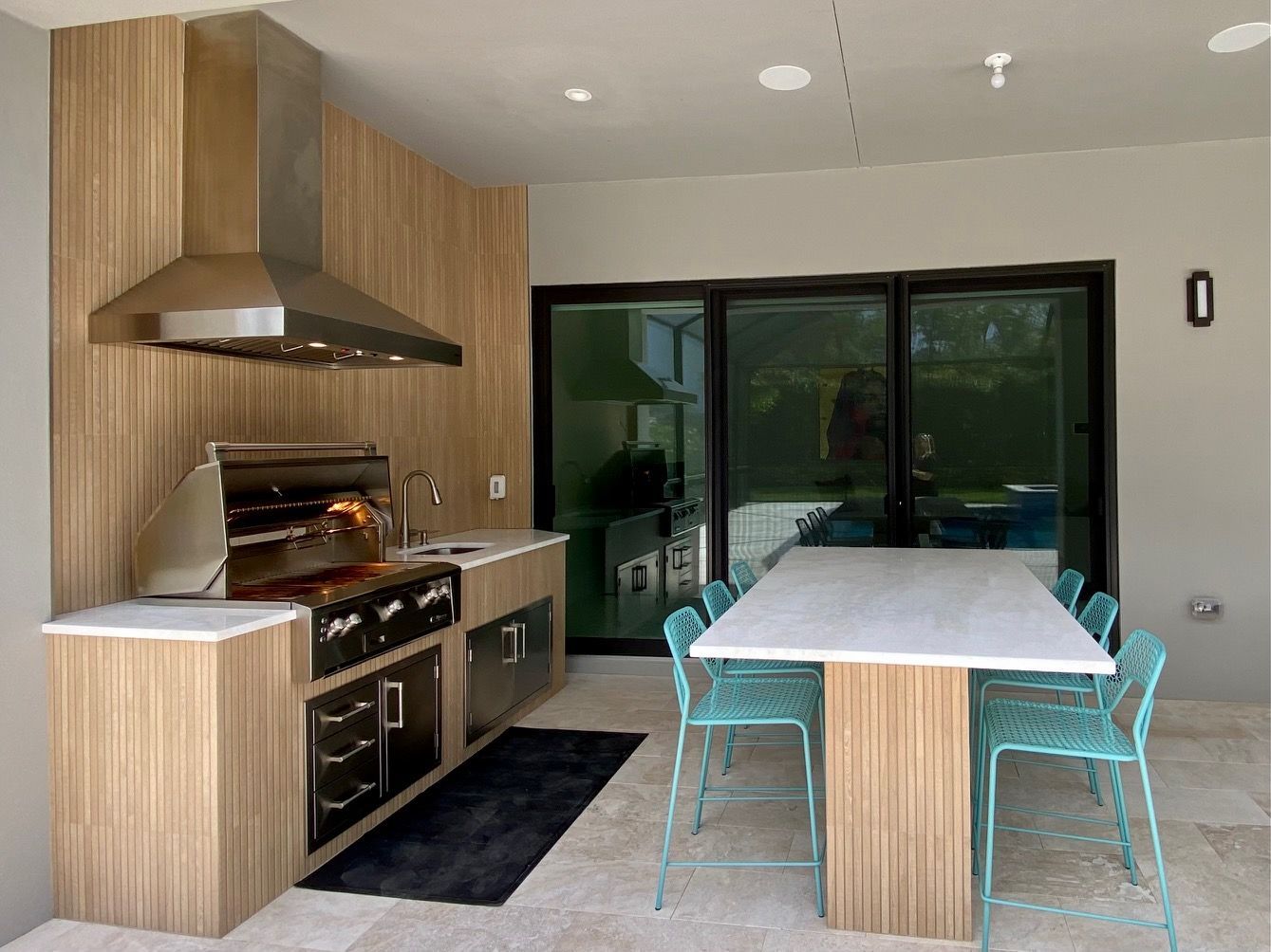 A kitchen with a table and chairs and a grill.