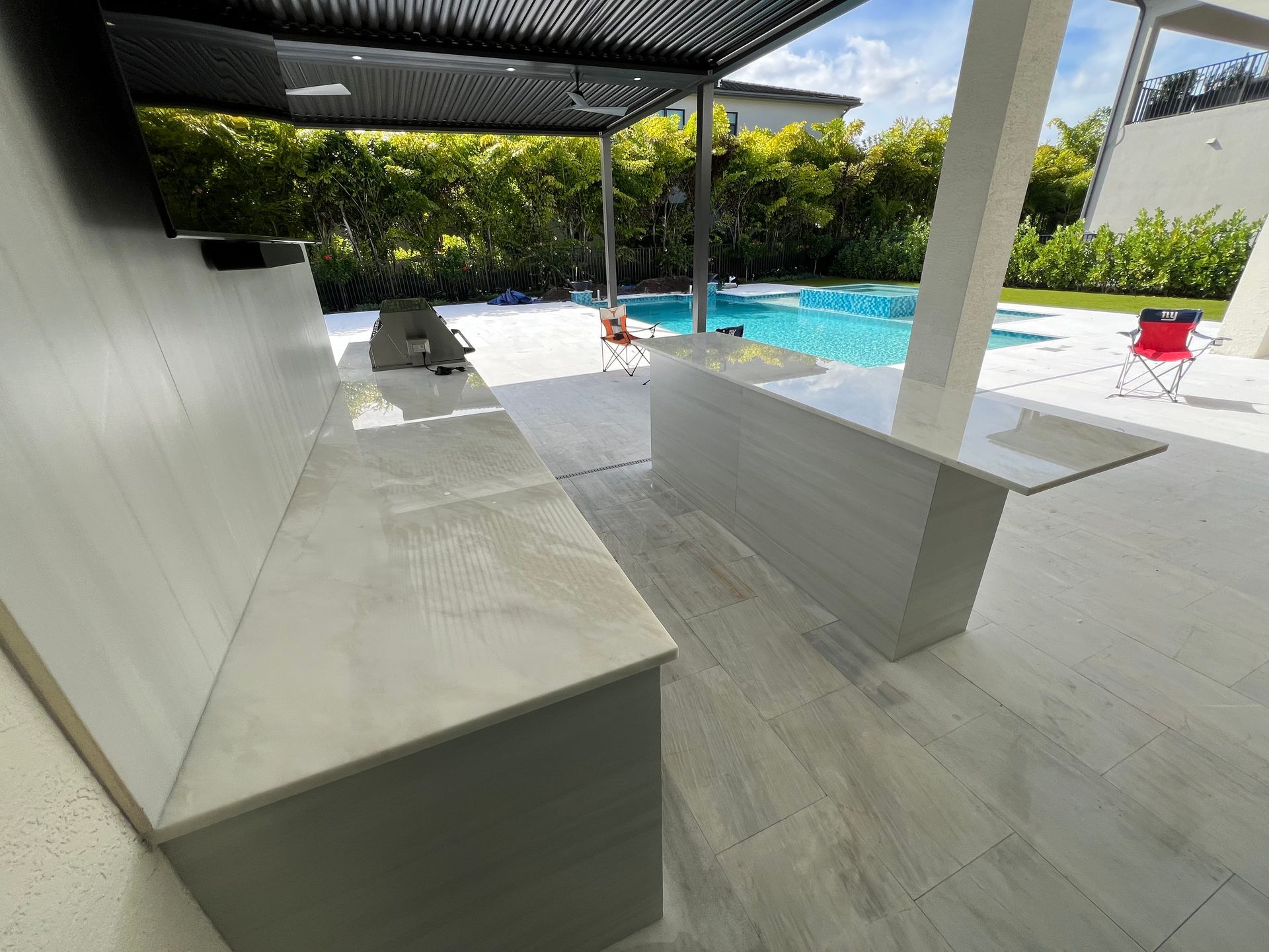 A patio area with a swimming pool in the background