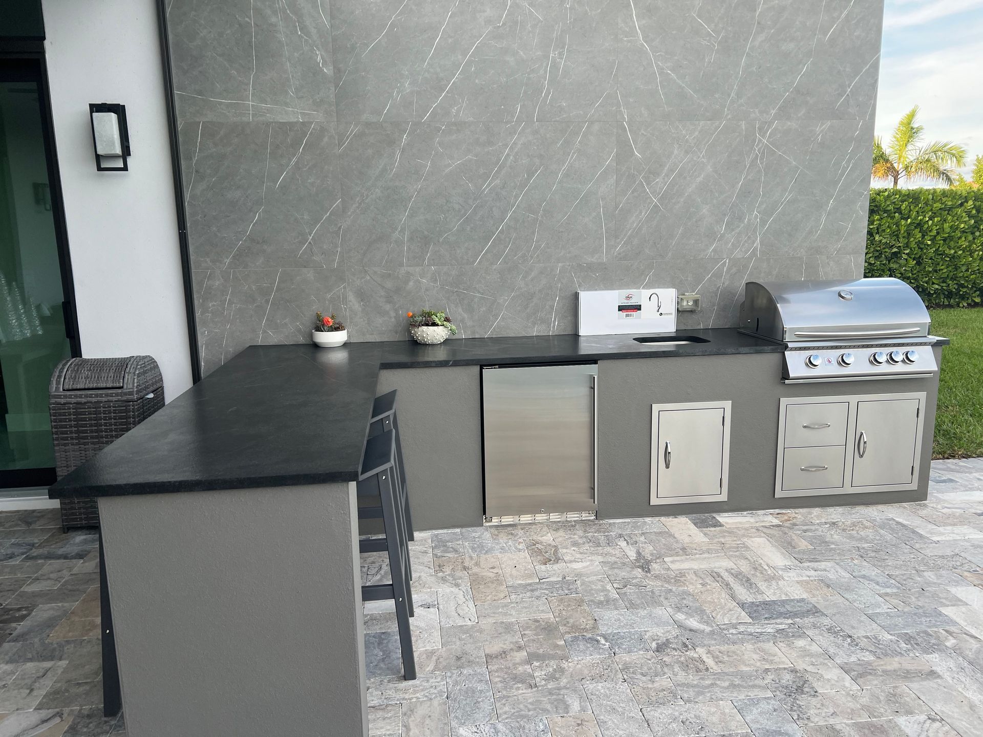 An outdoor kitchen with a grill and a sink