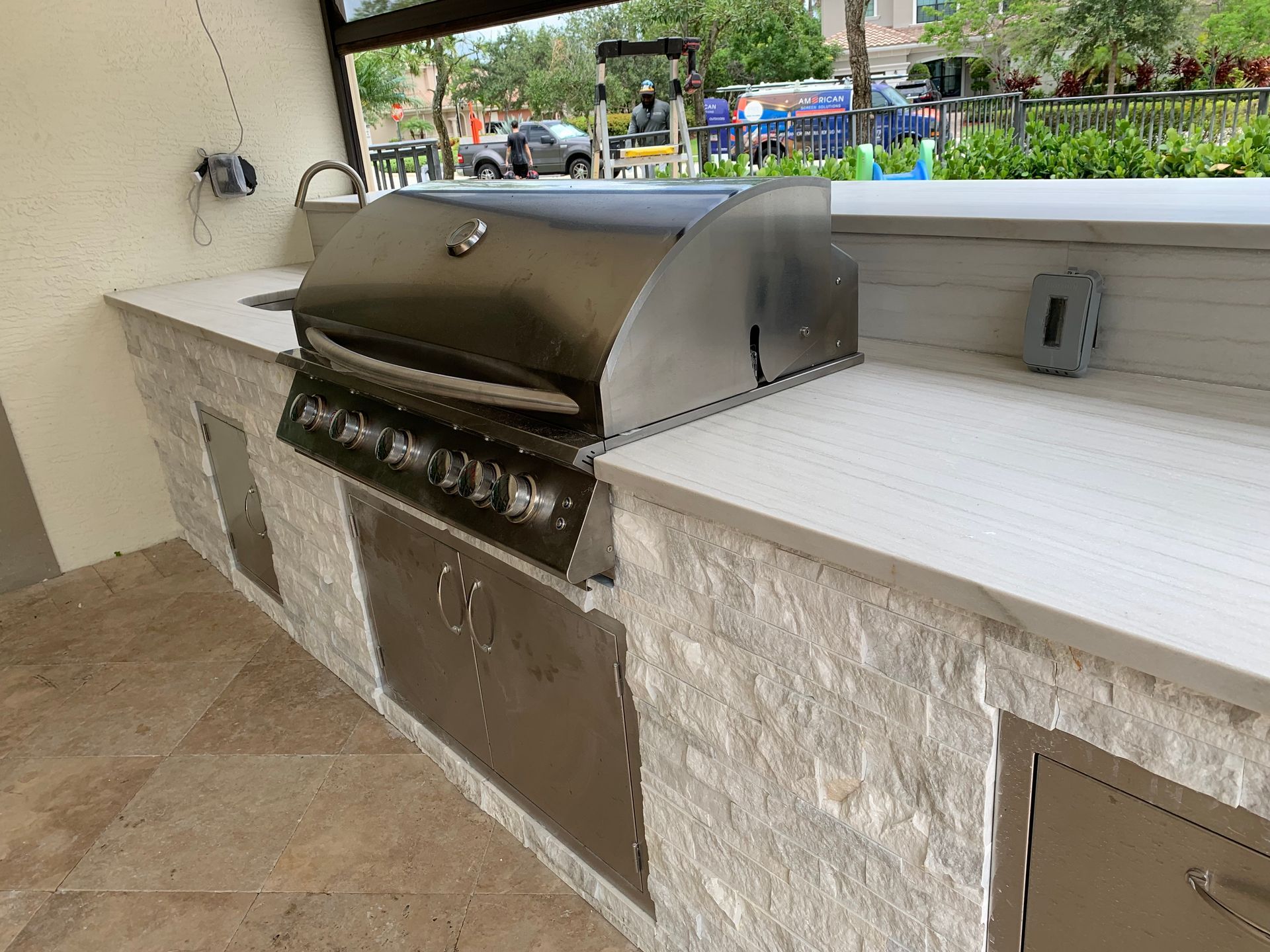 A stainless steel grill is sitting on top of a counter in a kitchen.