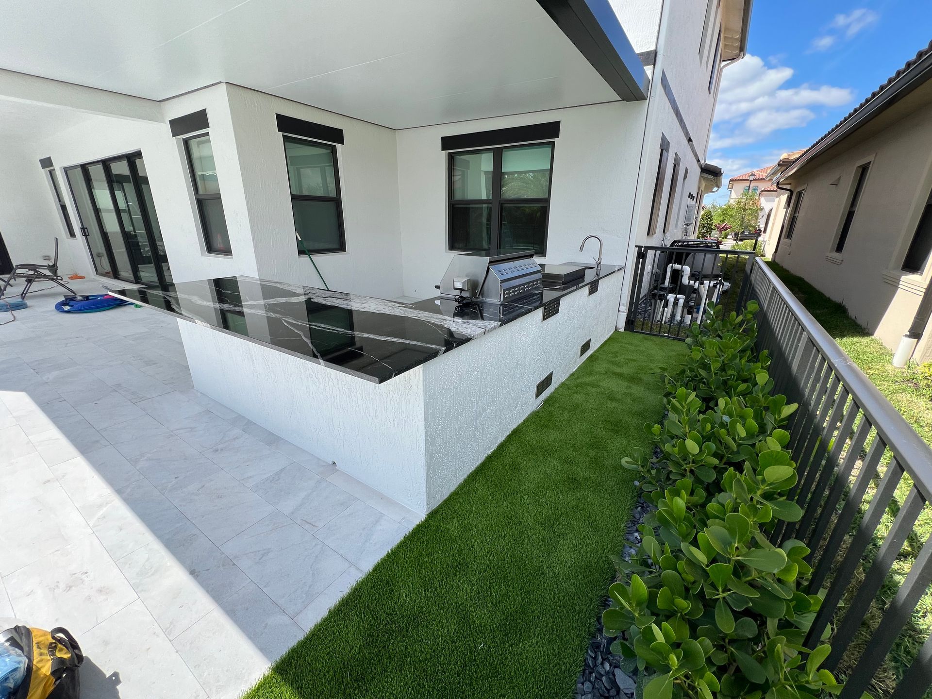 A white house with a fence and a lawn in front of it.