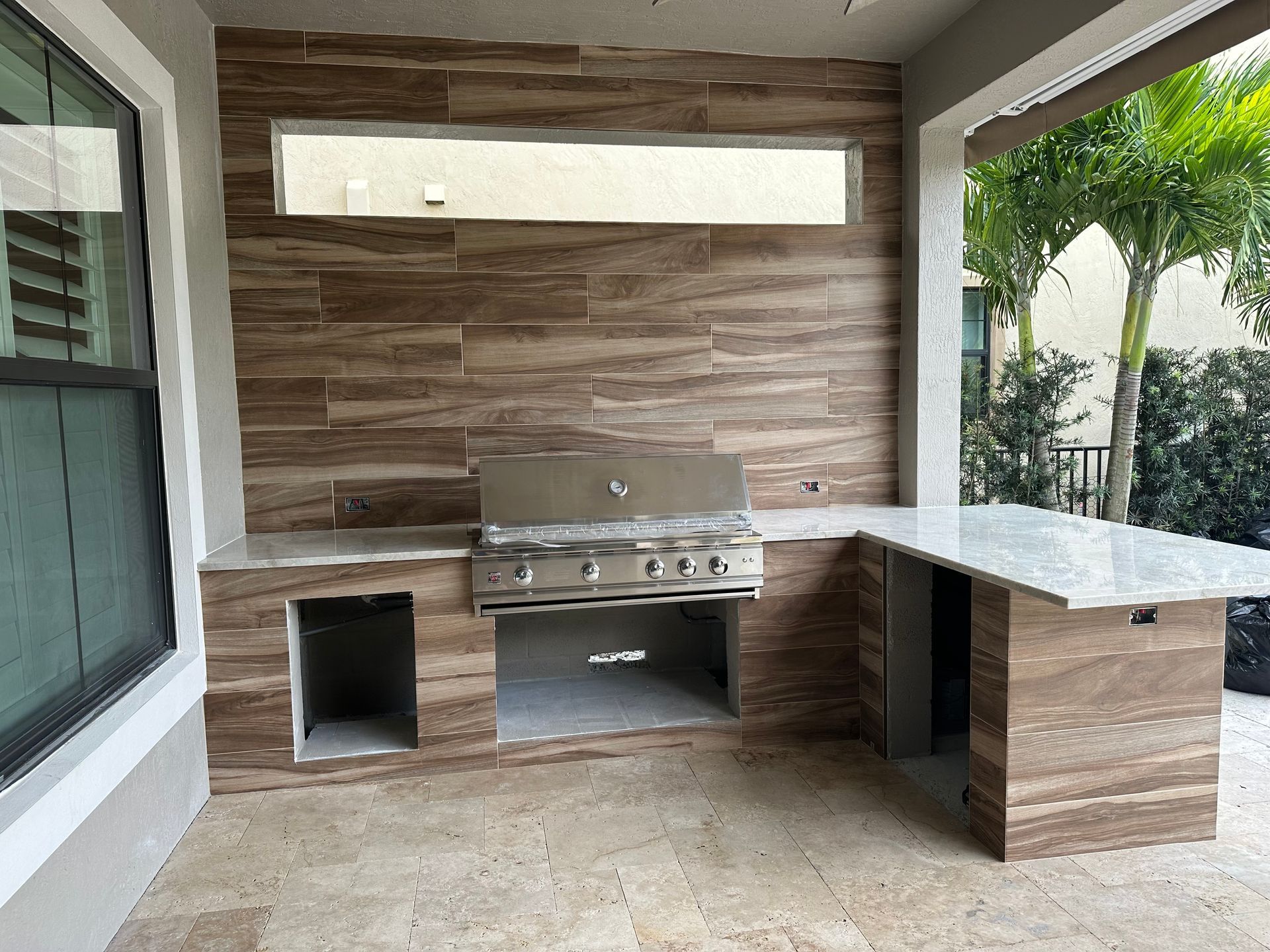 An outdoor kitchen with a stove and a window