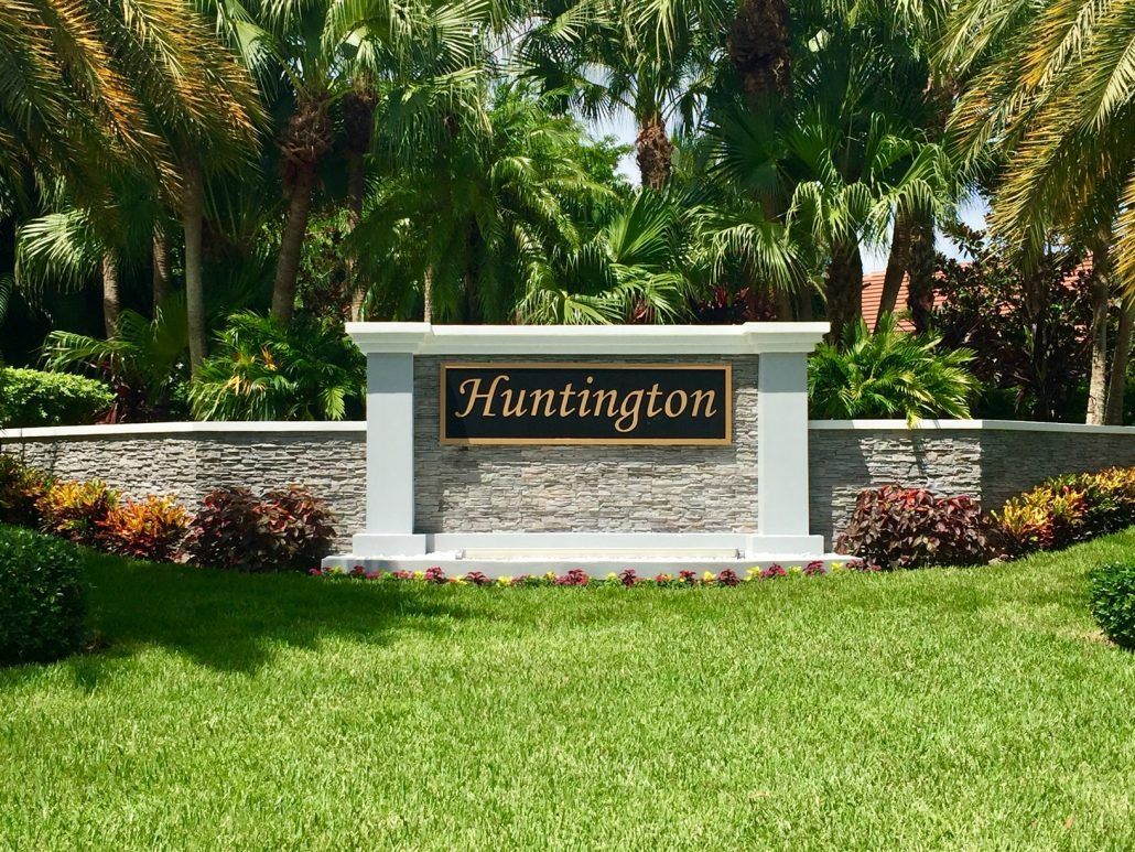 A sign for huntington is in the middle of a lush green field.