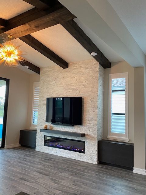A living room with a fireplace and a flat screen tv