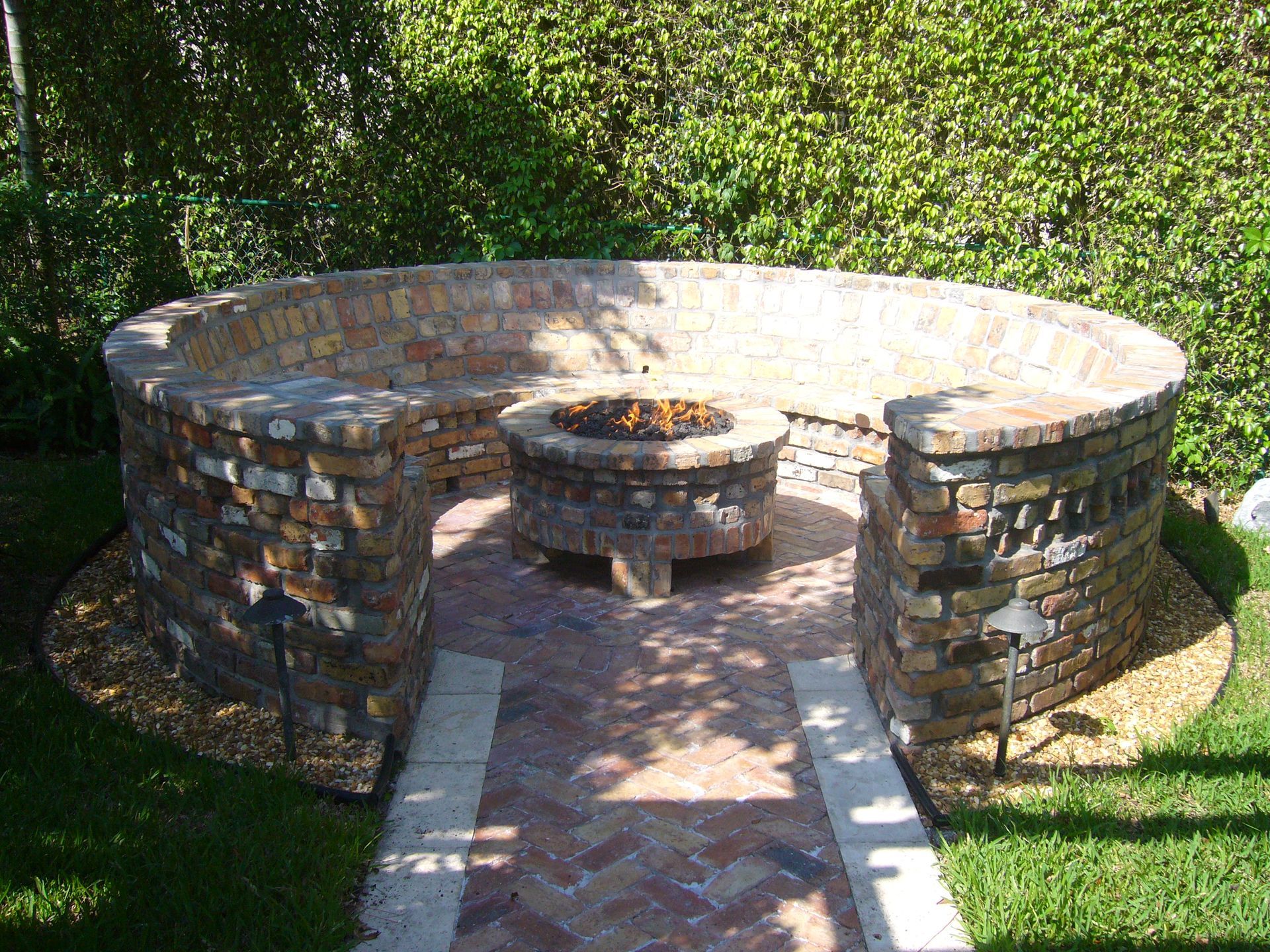 Circular brick firepit with built-in seating in Delray Beach, FL.
