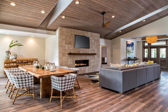 A living room with a wooden table and chairs and a fireplace.