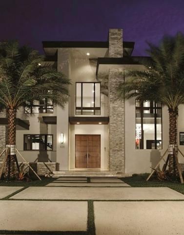 Elegant home exterior with stone and brick accents, framed by palm trees in Boca Raton, FL.