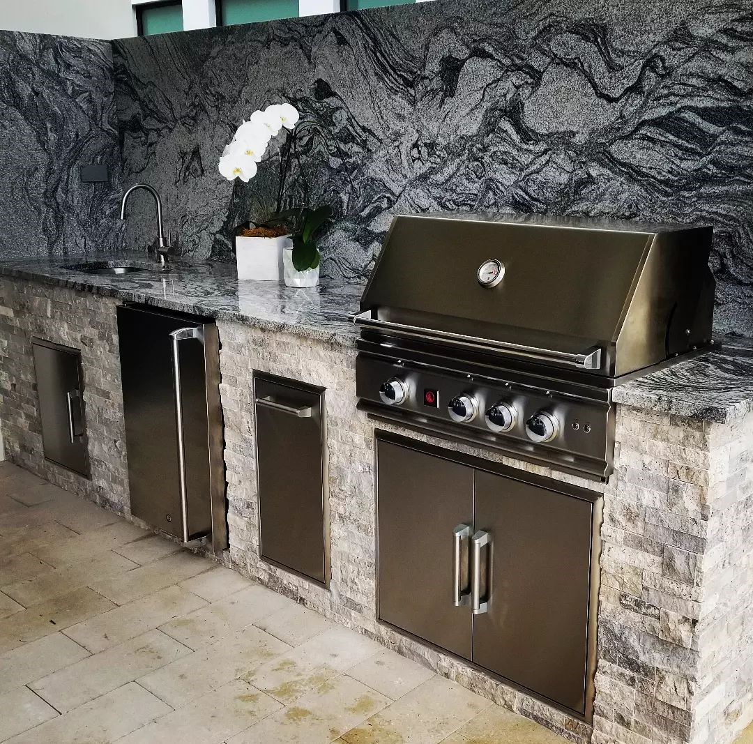 A kitchen with stainless steel cabinets and a grill