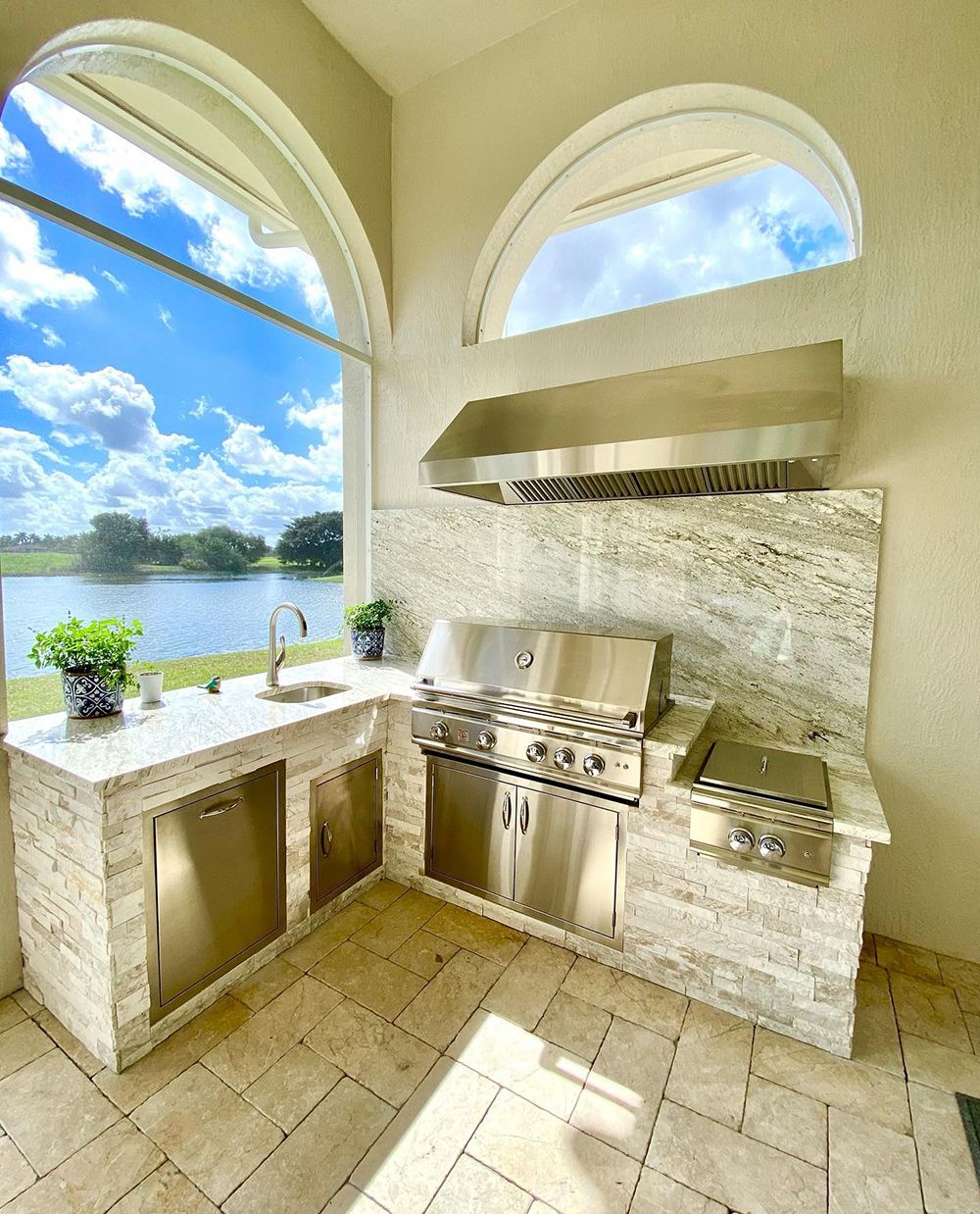 A kitchen with stainless steel appliances and a large window overlooking a lake