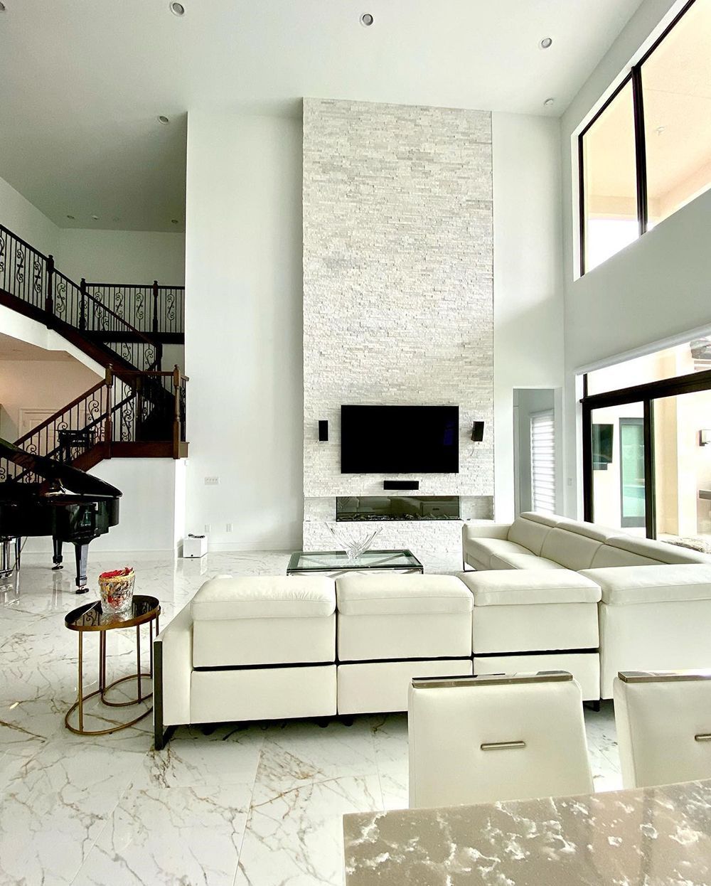 A living room with a piano, couch, table and television