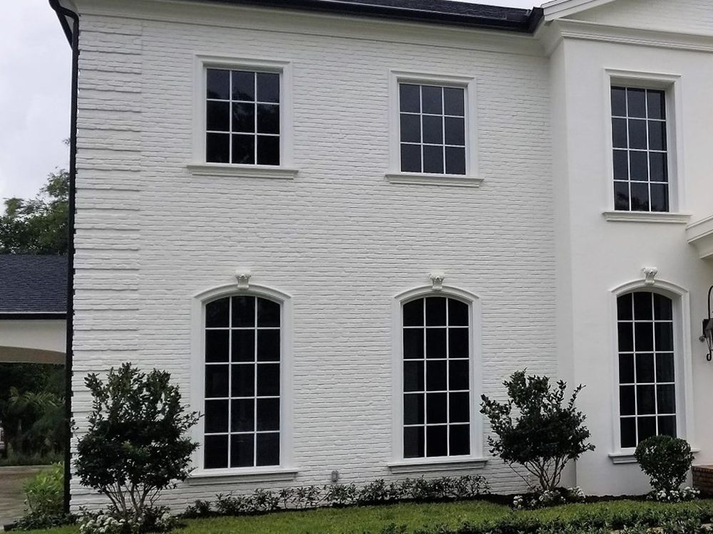 A white brick house with a lot of windows