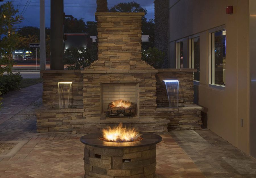 A stone fireplace with a fire pit in front of it