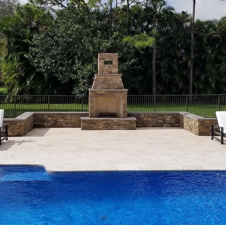 A swimming pool with a fireplace in the middle of it