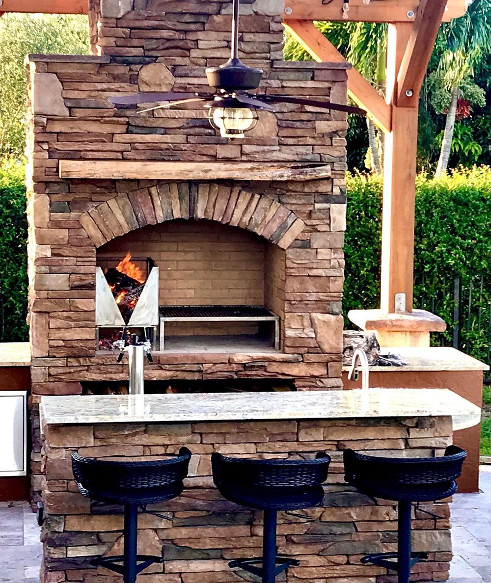 A stone fireplace with a ceiling fan above it
