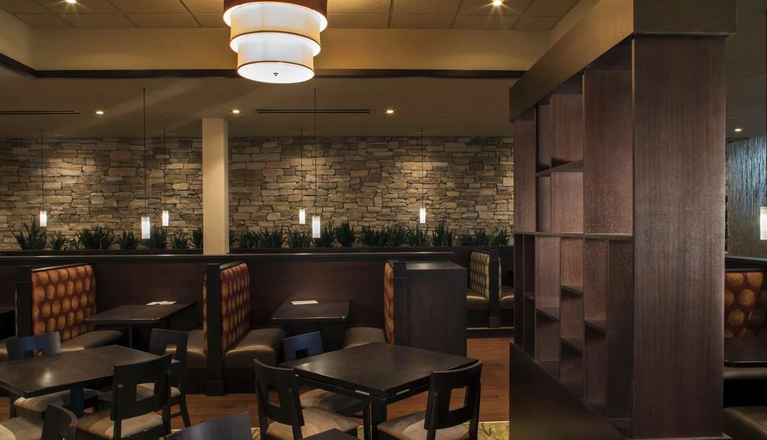 A restaurant with tables and chairs and a chandelier hanging from the ceiling.