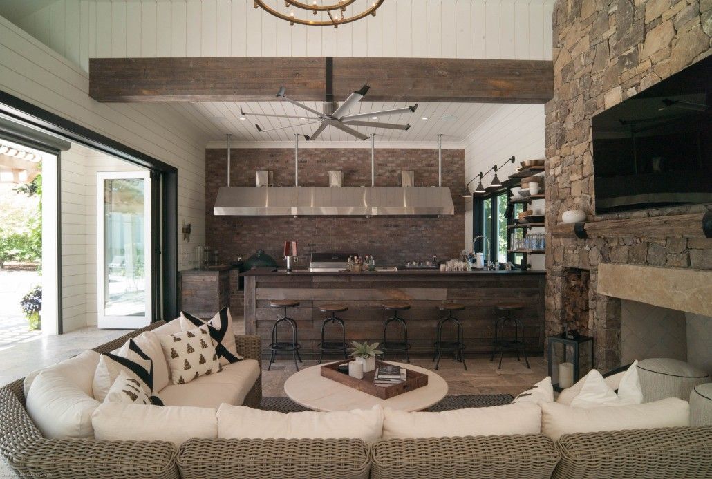 A living room with a couch and a fireplace and a kitchen in the background.