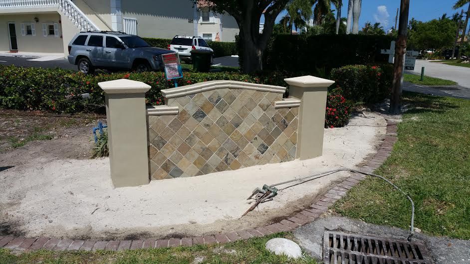 A stone wall is being built in front of a house.