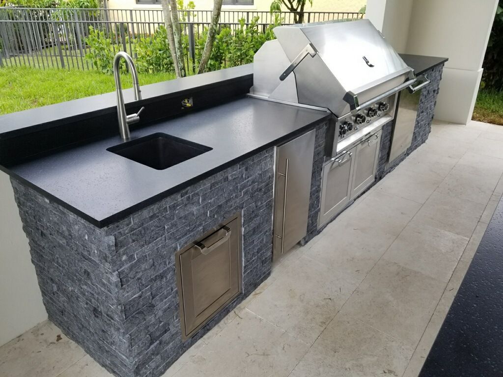 Sleek outdoor kitchen with stainless steel appliances and stone countertops in Fort Lauderdale, FL.