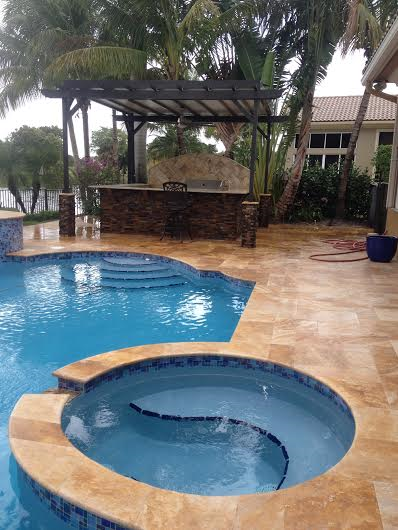 A large swimming pool with a hot tub in the middle of it.