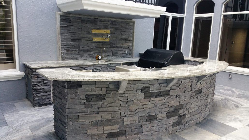 A large stone bar with a grill on top of it.